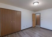 Thumbnail 18 of 21 - a bedroom of an apartment with a door to the hallway and a closet. Fargo, ND Prairiewood Courts Apartments