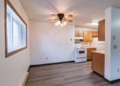 Thumbnail 14 of 21 - an empty kitchen with a ceiling fan and a window. Fargo, ND Prairiewood Courts Apartments