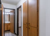Thumbnail 19 of 21 - the entrance to a bathroom with two closets and a mirror. Fargo, ND Prairiewood Courts Apartments