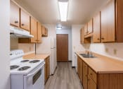 Thumbnail 12 of 21 - a kitchen with stove refrigerator and sink. Fargo, ND Prairiewood Courts Apartments