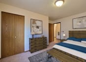 Thumbnail 6 of 21 - Fargo, ND Prairiewood Courts Apartments.  a bedroom with a bed and a dresser. A closet is in the corner of the room for extra storage.