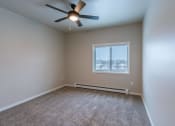 Thumbnail 14 of 26 - an empty room with a ceiling fan and a window. Fargo, ND Prairiewood Meadows | LivingFargo, ND Prairiewood Meadows