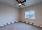 Thumbnail 20 of 26 - an empty room with a ceiling fan and a window. Fargo, ND Prairiewood Meadows Apartments