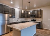 Thumbnail 17 of 26 - a kitchen with stainless steel appliances and a marble counter top. Fargo, ND Prairiewood Meadows Apartments