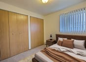 Thumbnail 7 of 20 - Fargo, ND Saddlebrook Apartments. a bedroom with a bed and two closets