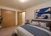 Thumbnail 8 of 20 - Fargo, ND Saddlebrook Apartments. a bedroom with a large bed and a potted plant