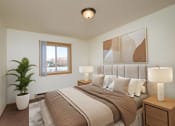 Thumbnail 3 of 22 - a bedroom with a large bed and a potted plant. Fargo, ND Sargent Apartments