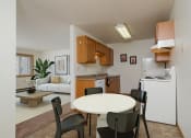 Thumbnail 2 of 22 - a kitchen and dining room with a white table and chairs. Fargo, ND Sargent Apartments