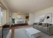 Thumbnail 4 of 22 - a living room with a couch and a coffee table and a dining room and kitchen. Fargo, ND Sargent Apartments