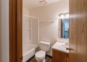 Thumbnail 17 of 22 - a bathroom with a toilet and a tub and a sink. Fargo, ND Sargent Apartments