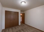Thumbnail 15 of 22 - a bedroom with a closet and a door to a hallway. Fargo, ND Sargent Apartments