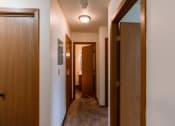 Thumbnail 16 of 22 - a hallway with two doors and a door to a bathroom. Fargo, ND Sargent Apartments.