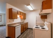 Thumbnail 9 of 22 - an empty kitchen with a stove refrigerator and sink. Fargo, ND Sargent Apartments