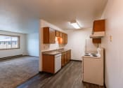 Thumbnail 10 of 22 - an empty kitchen with white appliances and wooden cabinets. Fargo, ND Sargent Apartments