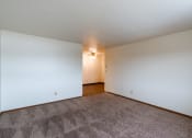 Thumbnail 7 of 22 - a spacious living room with carpet and white walls. Fargo, ND Sargent Apartments