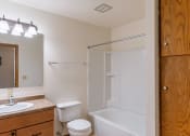 Thumbnail 9 of 10 - a bathroom with a shower toilet and sink and a mirror. Fargo, ND Schrock Apartments