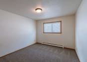 Thumbnail 6 of 10 - a bedroom with white walls and a window. Fargo, ND Schrock Apartments