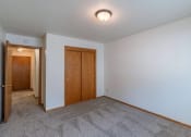 Thumbnail 8 of 10 - a bedroom with carpet and white walls. Fargo, ND Schrock Apartments