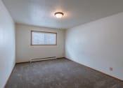 Thumbnail 7 of 10 - a bedroom with white walls and a window. Fargo, ND Schrock Apartments