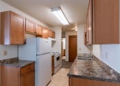 Thumbnail 4 of 10 - a kitchen with white appliances and granite counter tops. Fargo, ND Schrock Apartments