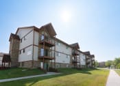 Thumbnail 1 of 2 - The exterior of an apartment with three levels and a sidewalk out front. Fargo, ND Sheridan Pointe Apartment.