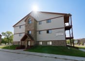 Thumbnail 2 of 2 - An exterior view of an apartment complex with a sidewalk in front of it. Fargo, ND Sheridan Pointe Apartments.