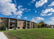 Thumbnail 19 of 19 - The exterior of a three level apartment building with a grass area out front. Fargo, ND South Pointe Apartments