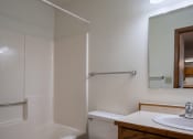 Thumbnail 22 of 25 - a bathroom with a sink and a shower and a mirror. Fargo, ND Southview Village Apartments