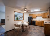 Thumbnail 2 of 25 - a kitchen and dining area with a white table and chairs. Fargo, ND Southview Village Apartments