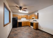 Thumbnail 18 of 25 - a kitchen with black appliances and tile flooring.  Fargo, ND Southview Village Apartments