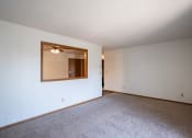 Thumbnail 16 of 25 - an empty living room with white walls and a large mirror. Fargo, ND Southview Village Apartments
