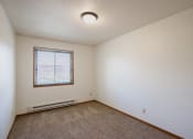 Thumbnail 12 of 25 - a bedroom with carpet and a window. Fargo, ND Southview Village Apartments