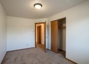 Thumbnail 13 of 25 - a bedroom with carpeted flooring and a door to a closet. Fargo, ND Southview Village Apartments