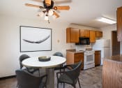 Thumbnail 5 of 25 - a kitchen and dining area with a table and chairs and a ceiling fan. Fargo, ND Southview Village Apartments