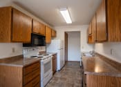 Thumbnail 8 of 25 - an empty kitchen with white appliances and wooden cabinets. Fargo, ND Southview Village Apartments