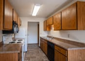 Thumbnail 9 of 25 - a kitchen with wooden cabinets and a stove and a sink. Fargo, ND Southview Village Apartments