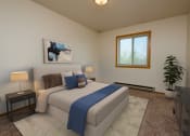 Thumbnail 4 of 10 - a bedroom with a bed, dresser, and window. Fargo, ND Southwind Apartments