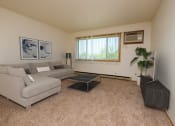 Thumbnail 1 of 10 - a living room with a couch, coffee table, and tv with a window. Fargo, ND Southwind Apartments