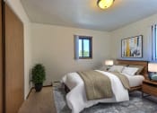 Thumbnail 3 of 14 - a bedroom with a bed and a potted plant. Fargo, ND Spring Apartments