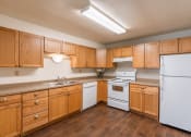 Thumbnail 7 of 14 - a kitchen with white appliances and wooden cabinets. Fargo, ND Spring Apartments