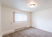 Thumbnail 8 of 14 - a bedroom with carpet and a window. Fargo, ND Spring Apartments