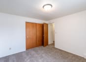Thumbnail 9 of 14 - a room with a carpeted floor and a door to a closet. Fargo, ND Spring Apartments