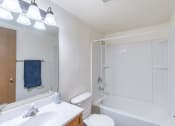 Thumbnail 12 of 14 - a bathroom with a white tub and a sink and a toilet. Fargo, ND Spring Apartments