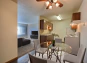 Thumbnail 3 of 10 - a kitchen and dining room with a glass table and chairs. Fargo, ND Sterling Park Apartments