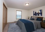 Thumbnail 3 of 43 - a bedroom with a bed and a door to a bathroom. Fargo, ND Stonebridge Apartments