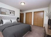 Thumbnail 2 of 43 - a bedroom with a bed and two closet doors. Fargo, ND Stonebridge Apartments