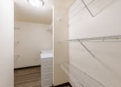 Thumbnail 35 of 43 - a closet with shelves and laundry machines. Fargo, ND Stonebridge Apartments