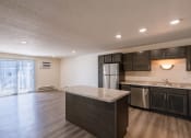 Thumbnail 28 of 43 - an empty kitchen with a marble counter top and a stainless steel refrigerator. Fargo, ND Stonebridge Apartments