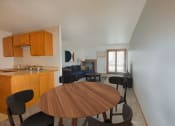 Thumbnail 3 of 10 - a dining area with a table and chairs and a living room with a couch and a fireplace