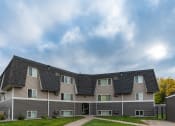 Thumbnail 1 of 2 - Fargo, ND Summerfield Apartments. A large apartment building with a roof shaped like a pyramid